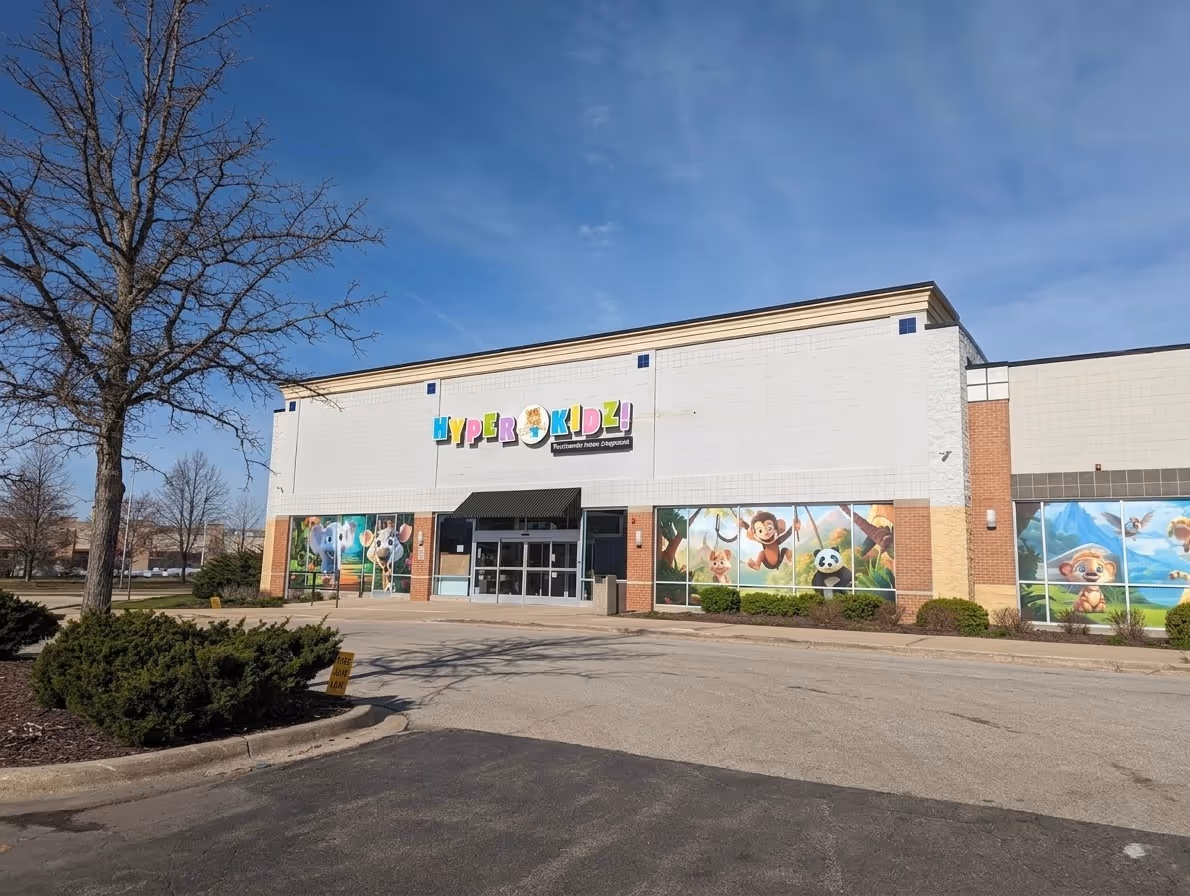 Exterior of Hyper Kidz children’s center with colorful animal murals and a clear blue sky.
