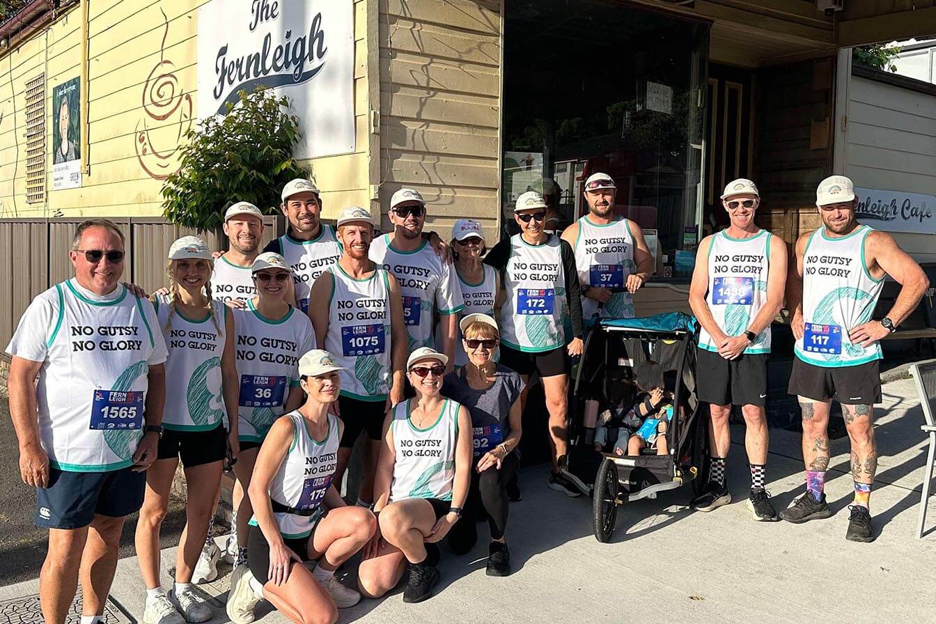 A large team of runners wearing "No Guts No Glory" singlets posing together
