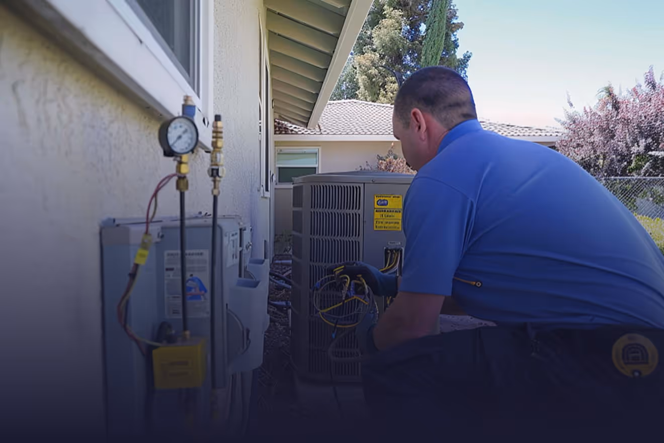 HVAC technician installing new air conditioning unit at Kern County residential home