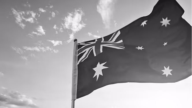 Success with CAPDA. Australian flag waving against a partly cloudy sky.