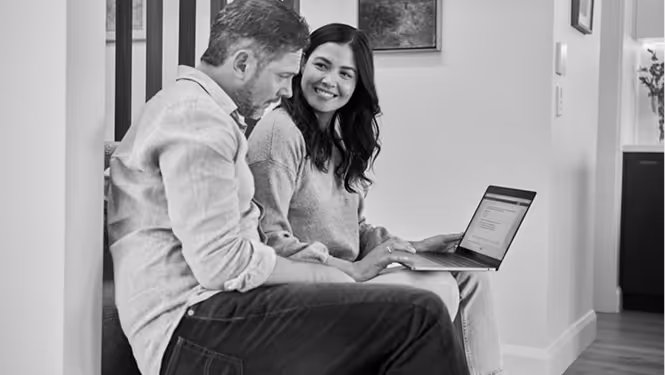 Success with CAPDA. Man and woman sitting side by side with the woman holding and showing content on a laptop.