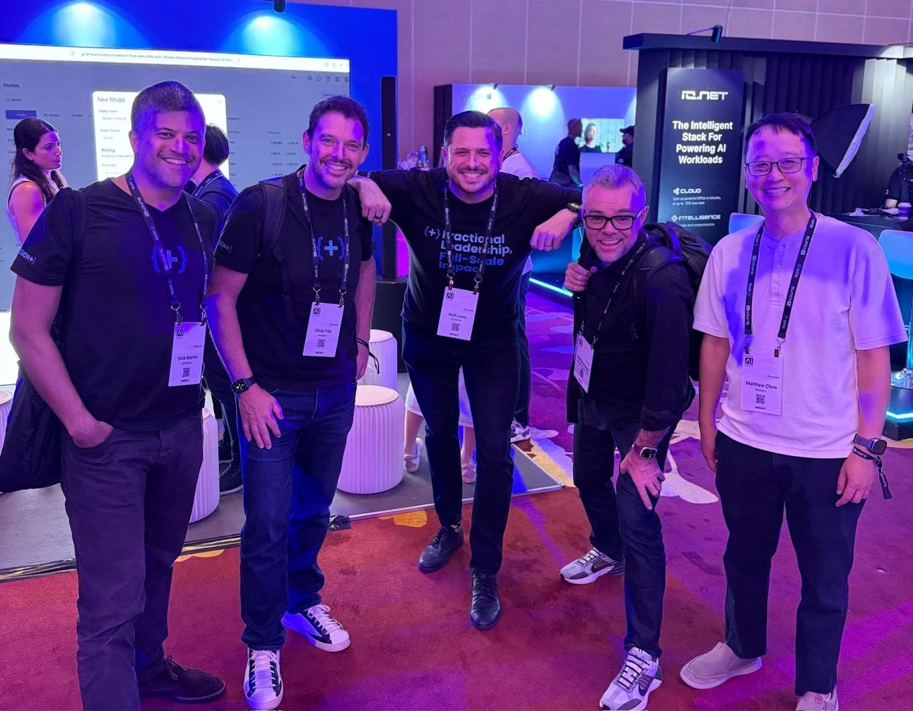 Five members of the MISSION+ team smiling together on the exhibition floor at the SuperAI conference