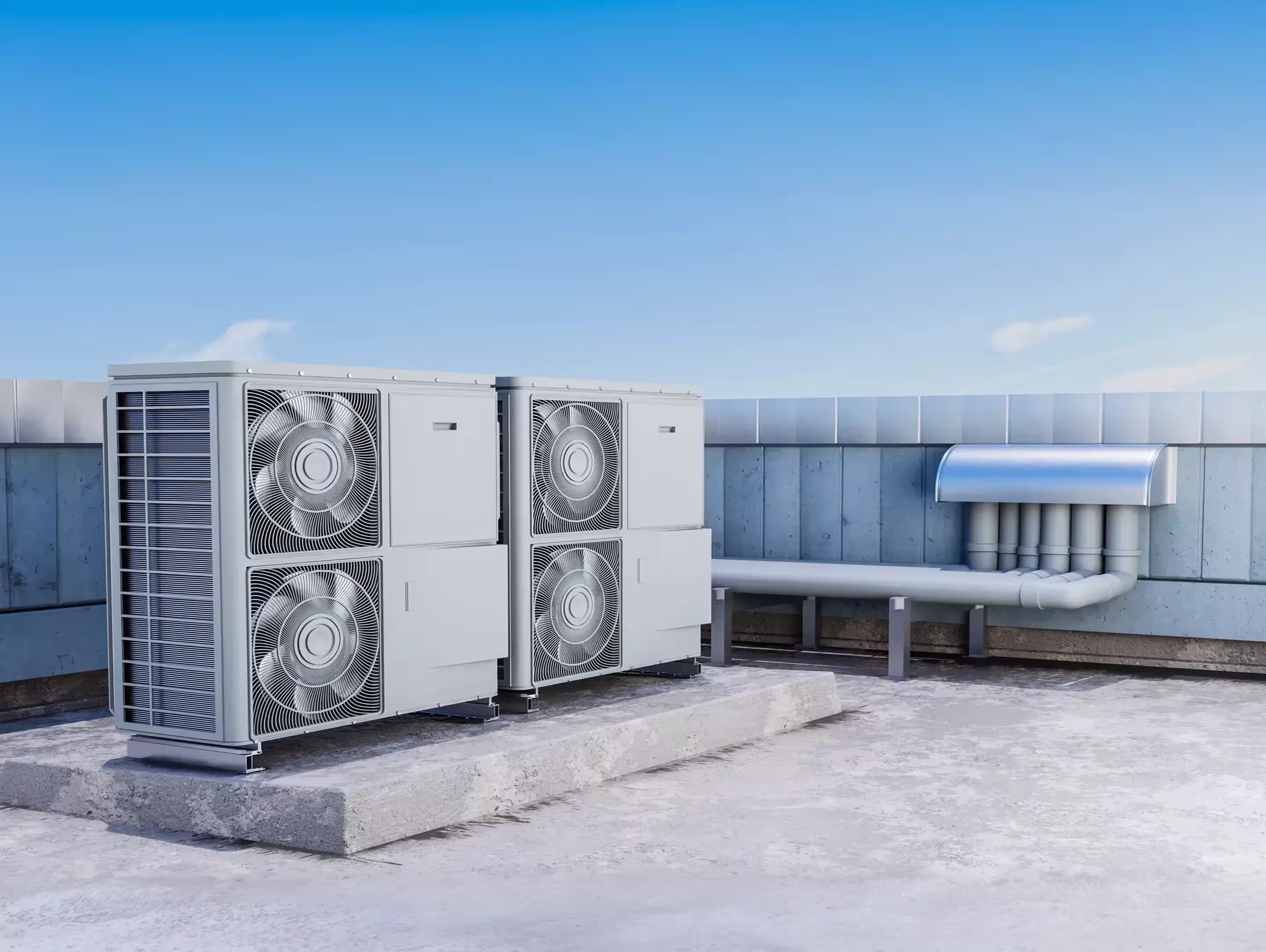 Two large industrial HVAC units with visible fans, installed on a rooftop platform next to ventilation pipes under a clear blue sky.