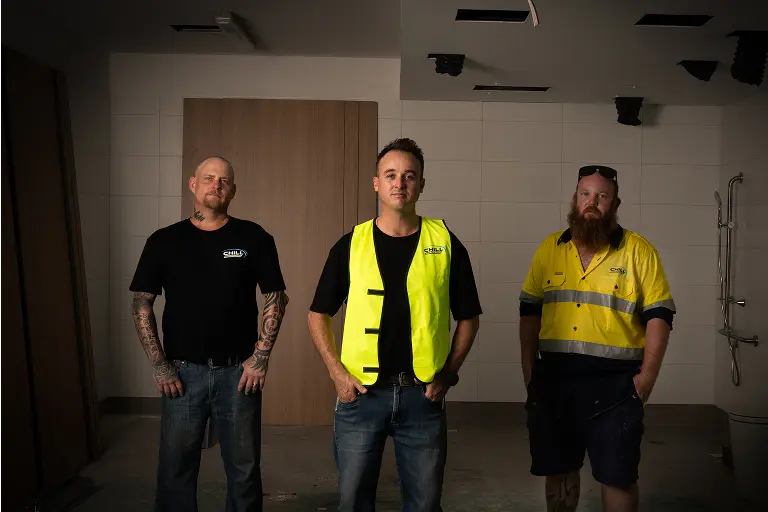 Three Chill Merchants team members standing together inside a commercial fit-out space with ceiling-mounted air conditioning cassettes