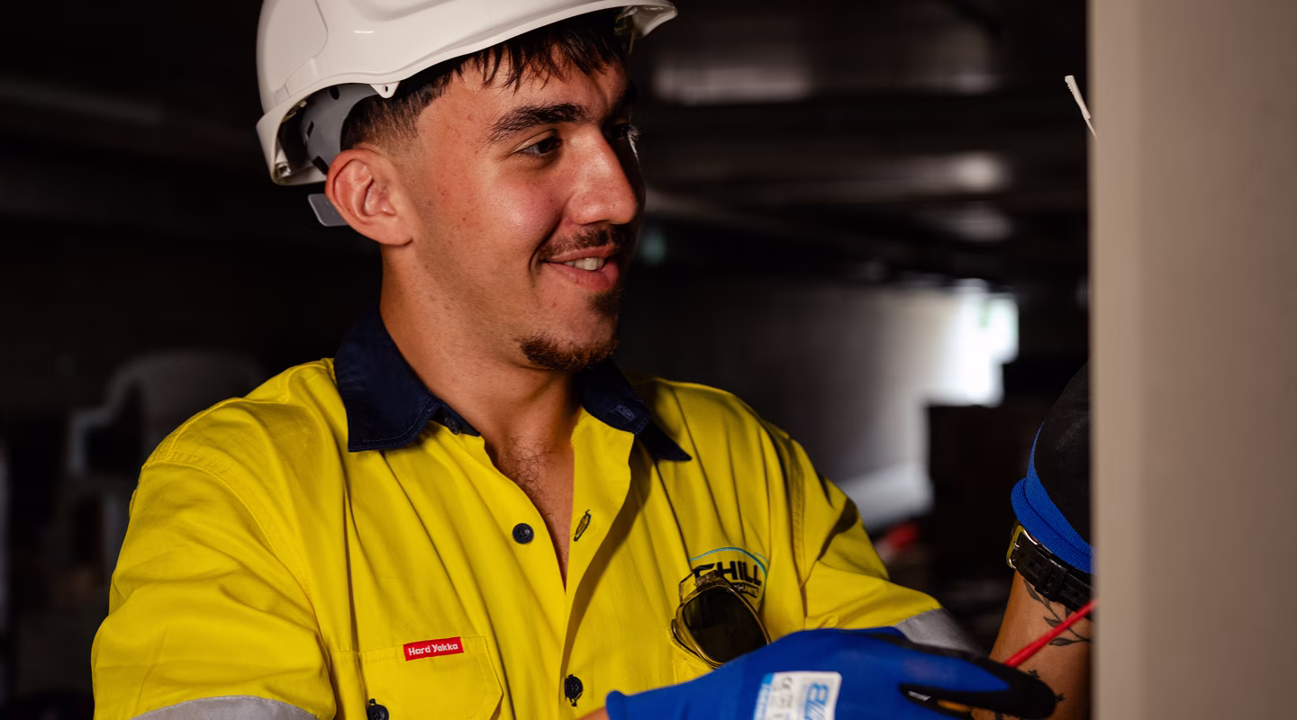 A Chill Merchants technician in a hard hat inspecting ventilation equipment on site