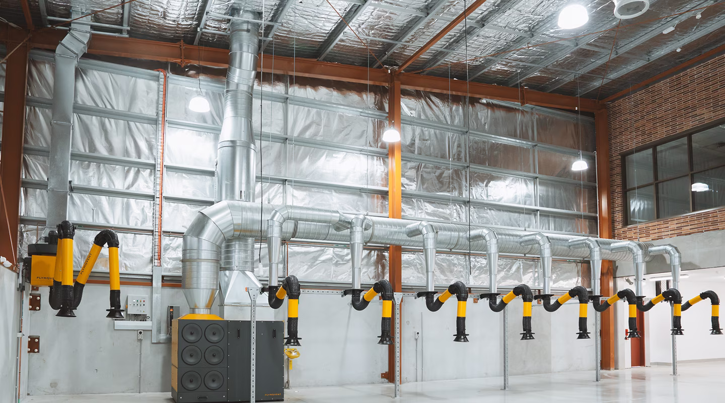 A commercial plant room with insulated pipework and Plymovent extraction arms