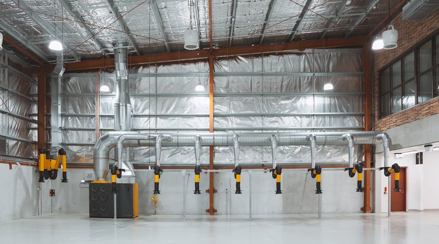 Insulated HVAC ductwork and mechanical pipework inside an industrial warehouse