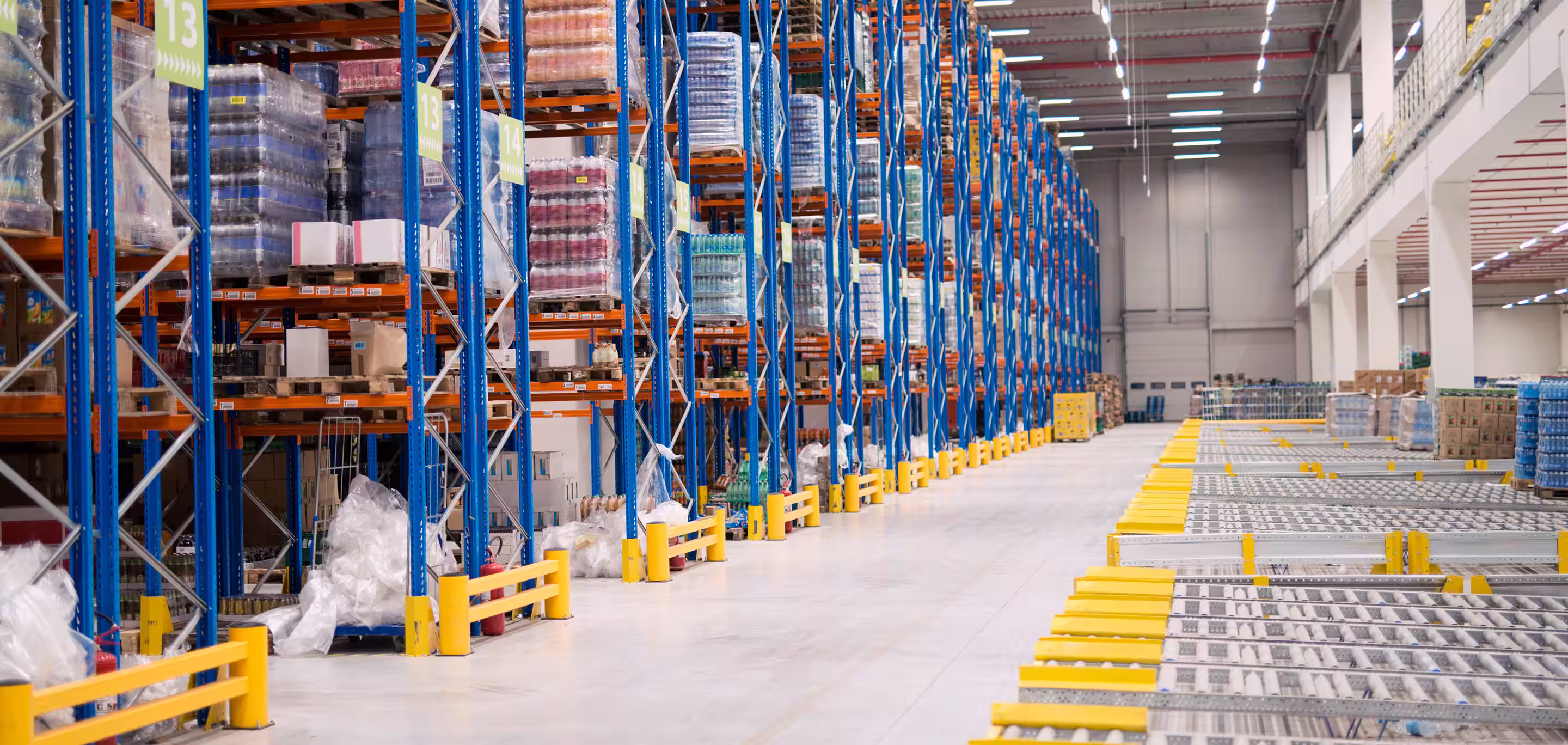 Large industrial warehouse interior with high racking and pallet storage requiring temperature-controlled ventilation and cooling