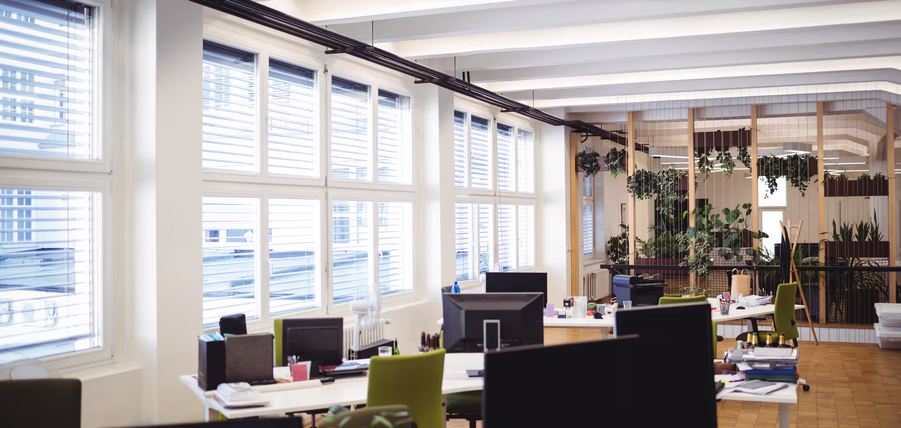 Open-plan commercial office interior with workstations, natural light, and ceiling-mounted air conditioning representing HVAC for office environments