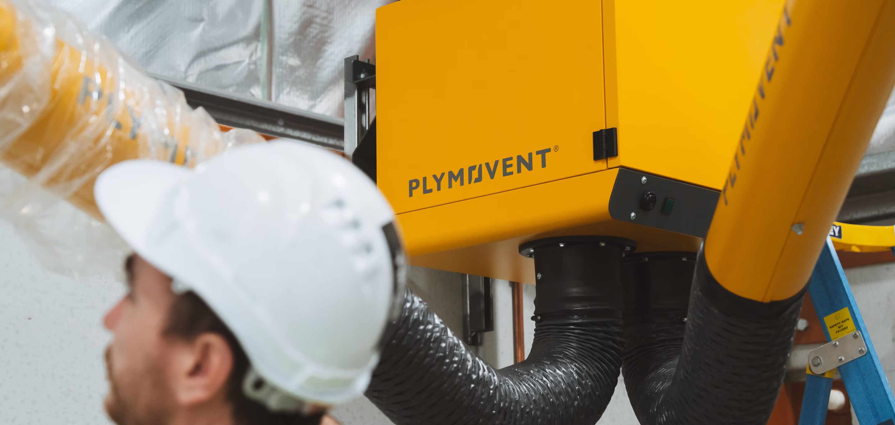 Plymovent commercial ventilation unit with flexible ducting representing HVAC systems requiring testing, adjusting and balancing