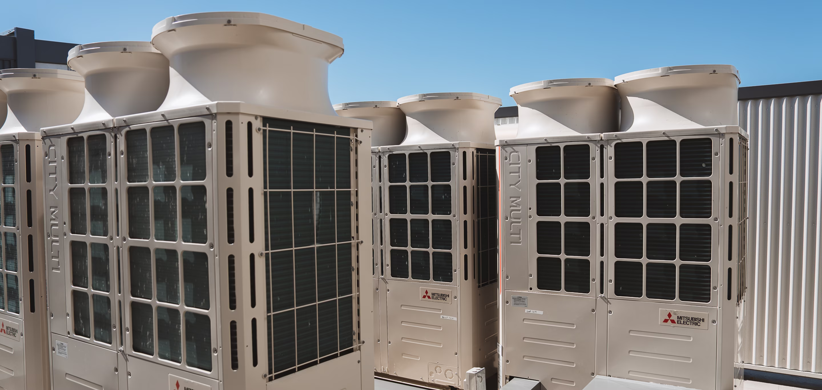 Large commercial Mitsubishi VRF condenser units installed on a rooftop as part of an HVAC plant replacement project