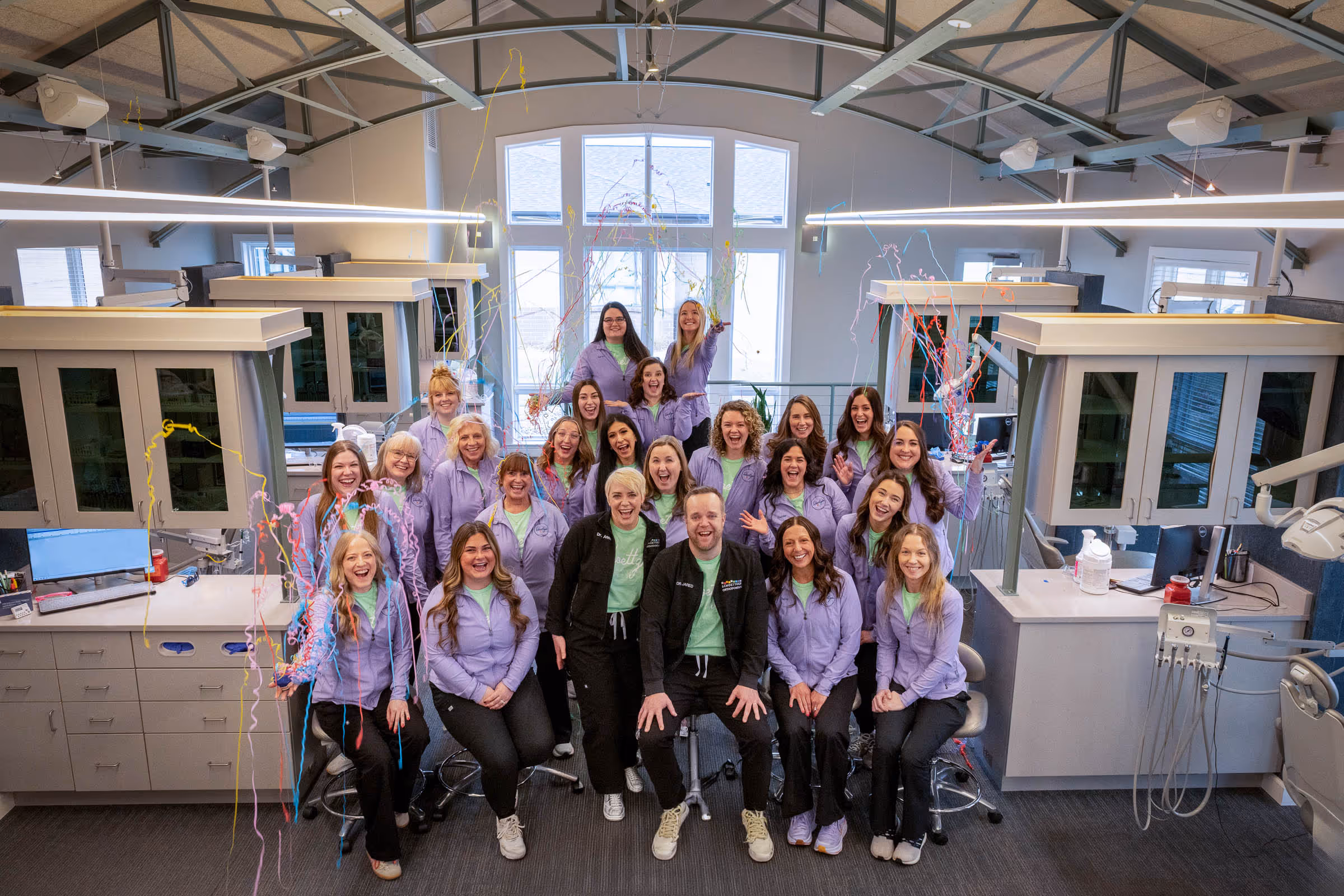 Schoettger Orthodontics team celebrating together with streamers in the clinic