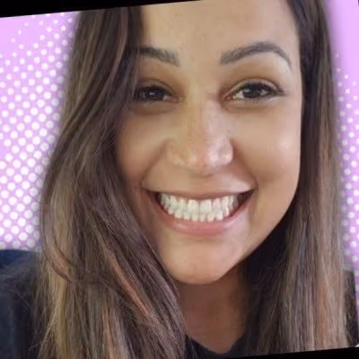 Close-up of a smiling woman with long brown hair and a purple dotted background.