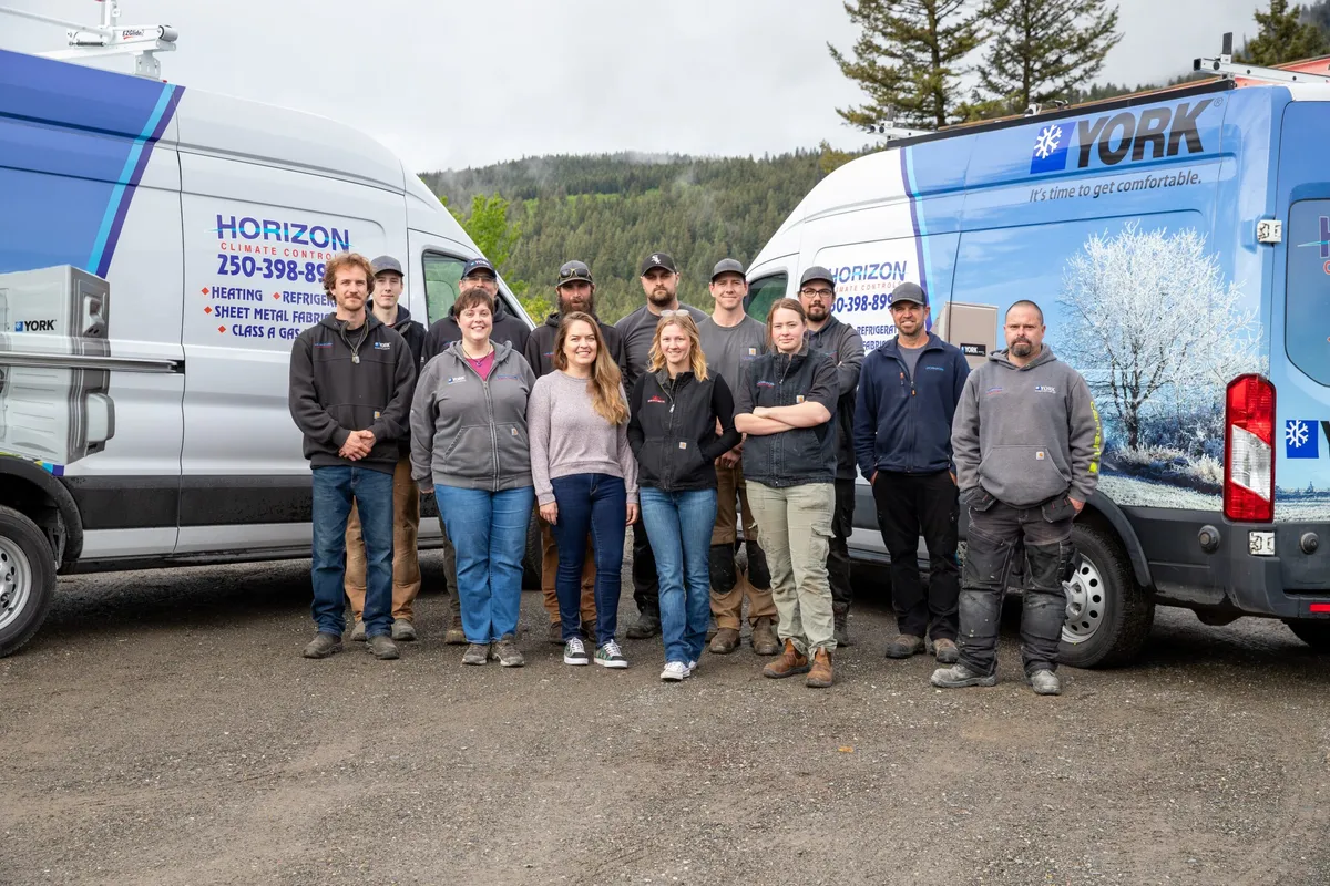 Group of Horizon Climate Control workers standing between two branded service vans outdoors.
