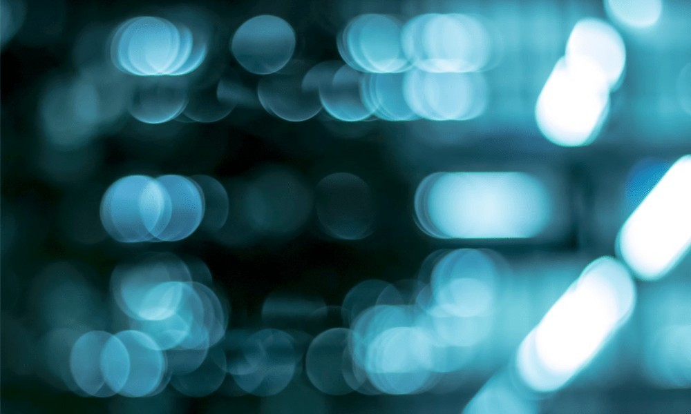 Blurred teal and blue bokeh lights on dark background