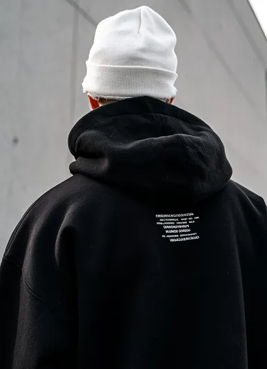 Back view of a person wearing a black hoodie and a white beanie