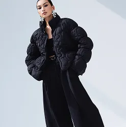 Model wearing an oversized black quilted jacket and wide-leg trousers