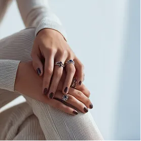 Close-up of hands wearing multiple rings and jewelry