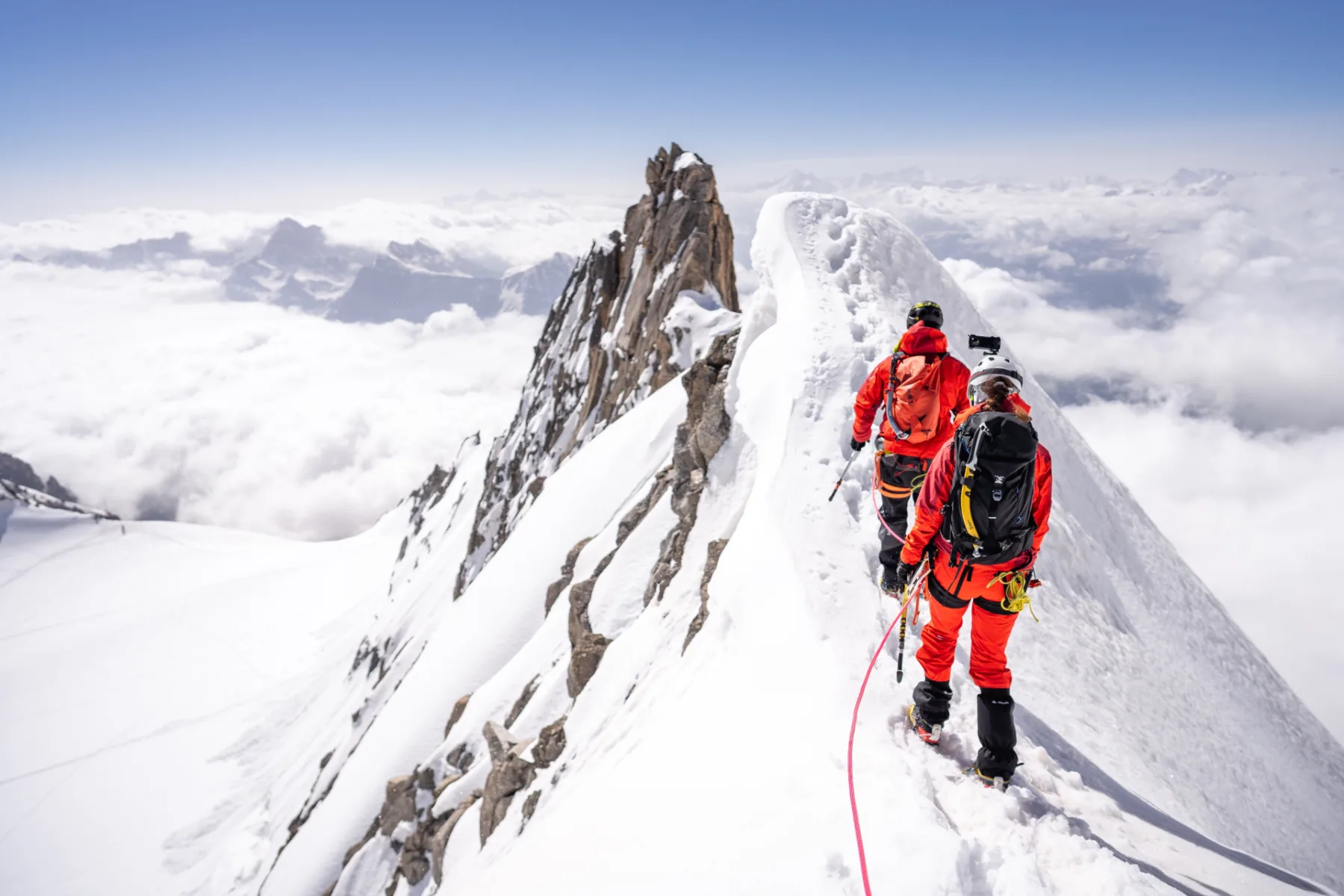 Dvojice na sněhovém hřebeni vysoko nad mraky, Mont Blanc