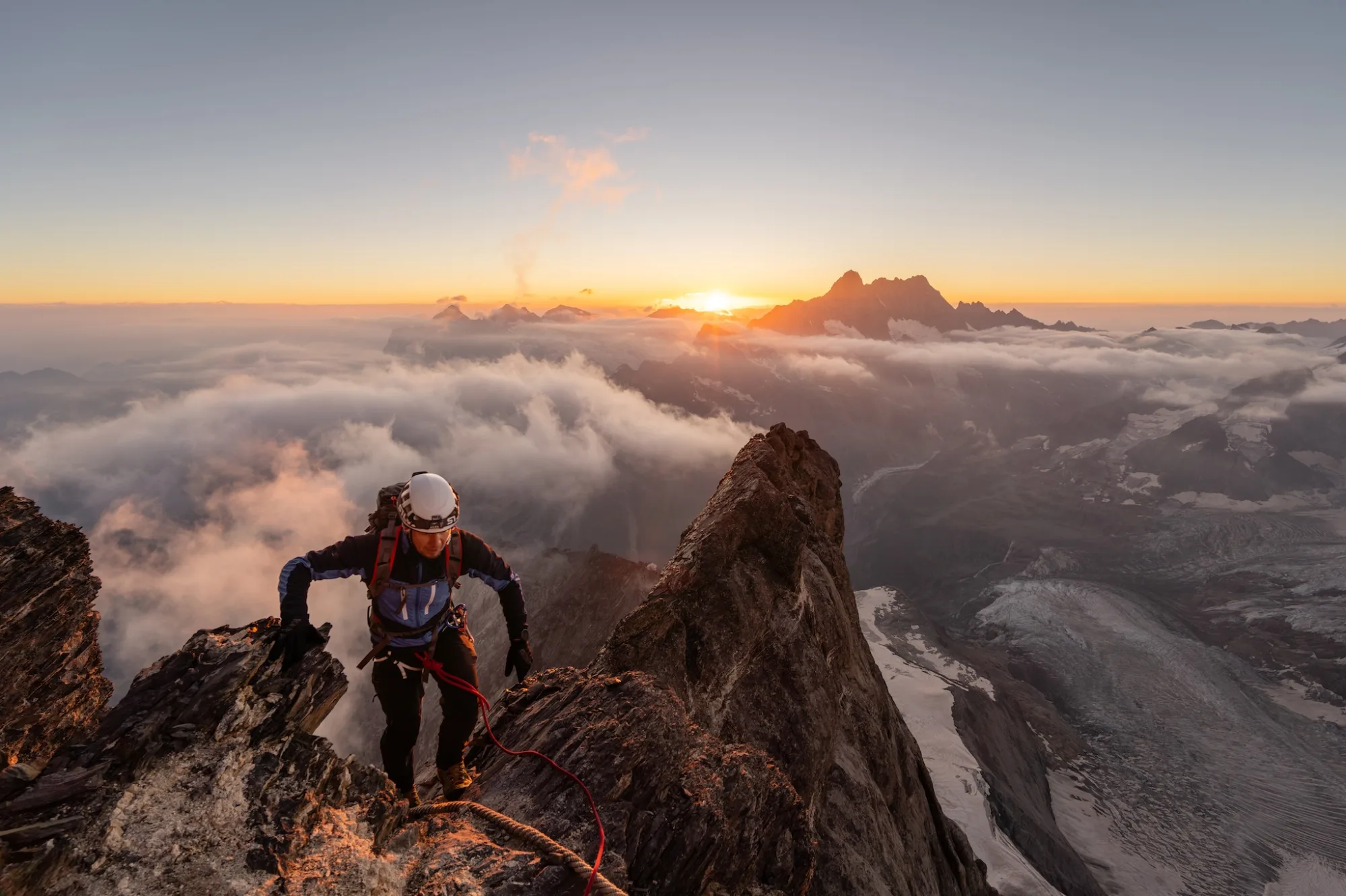 Horolezec na fixním laně leze hřeben Mittelegi na Eiger