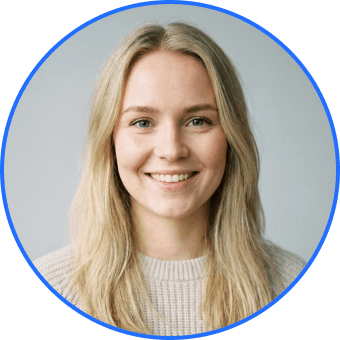 Smiling young woman with long blonde hair wearing a light sweater against a neutral background, framed by a blue circular border.
