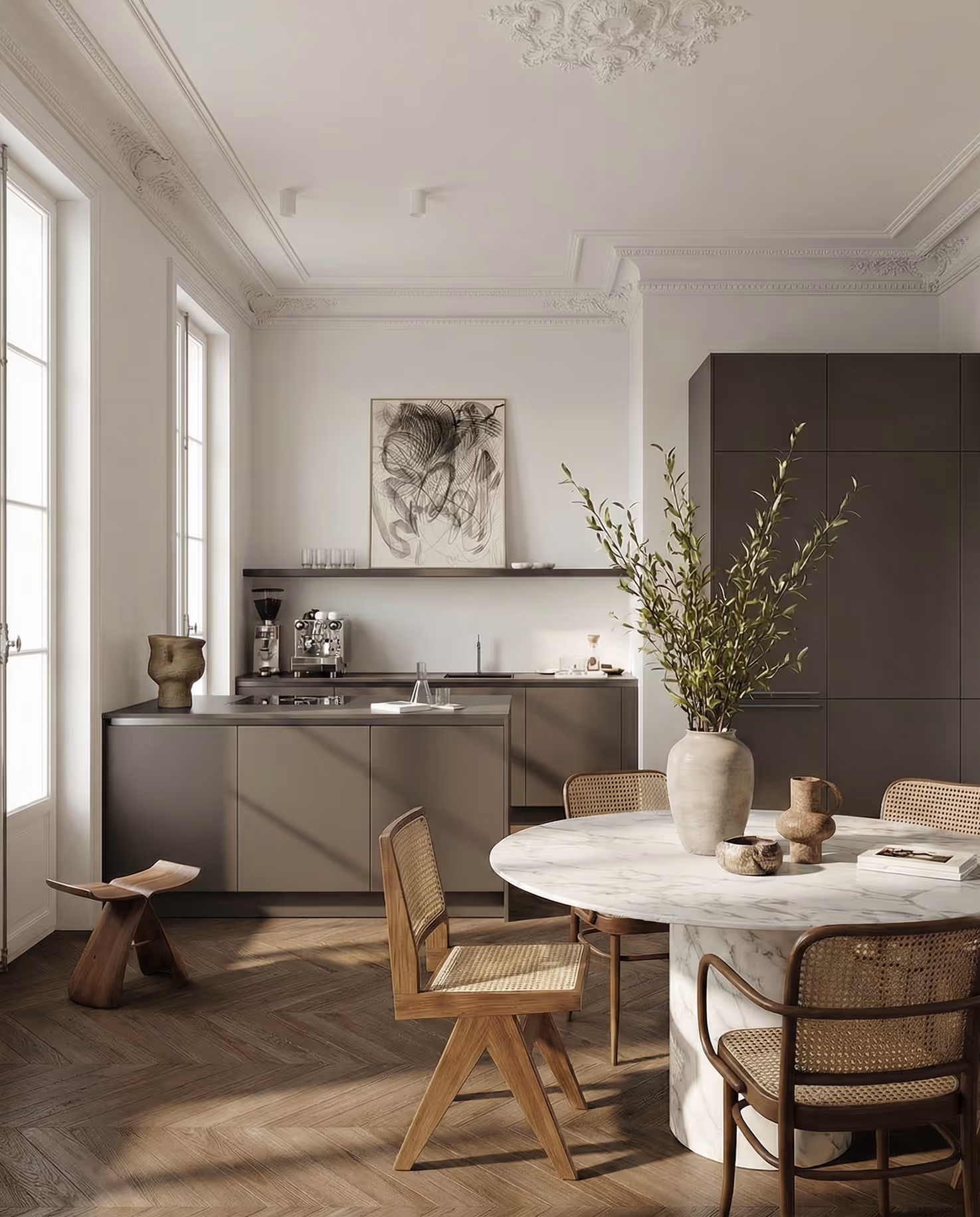 Moderne Küche mit grauen Schränken, rundem Marmor-Esstisch, Holzstuhl mit Geflecht und großer Vase mit Grünpflanzen.