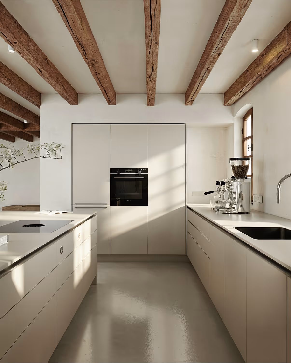 Moderne Küche mit weißen Schränken, Holzdeckenbalken und Kaffeemaschine neben Fenster.