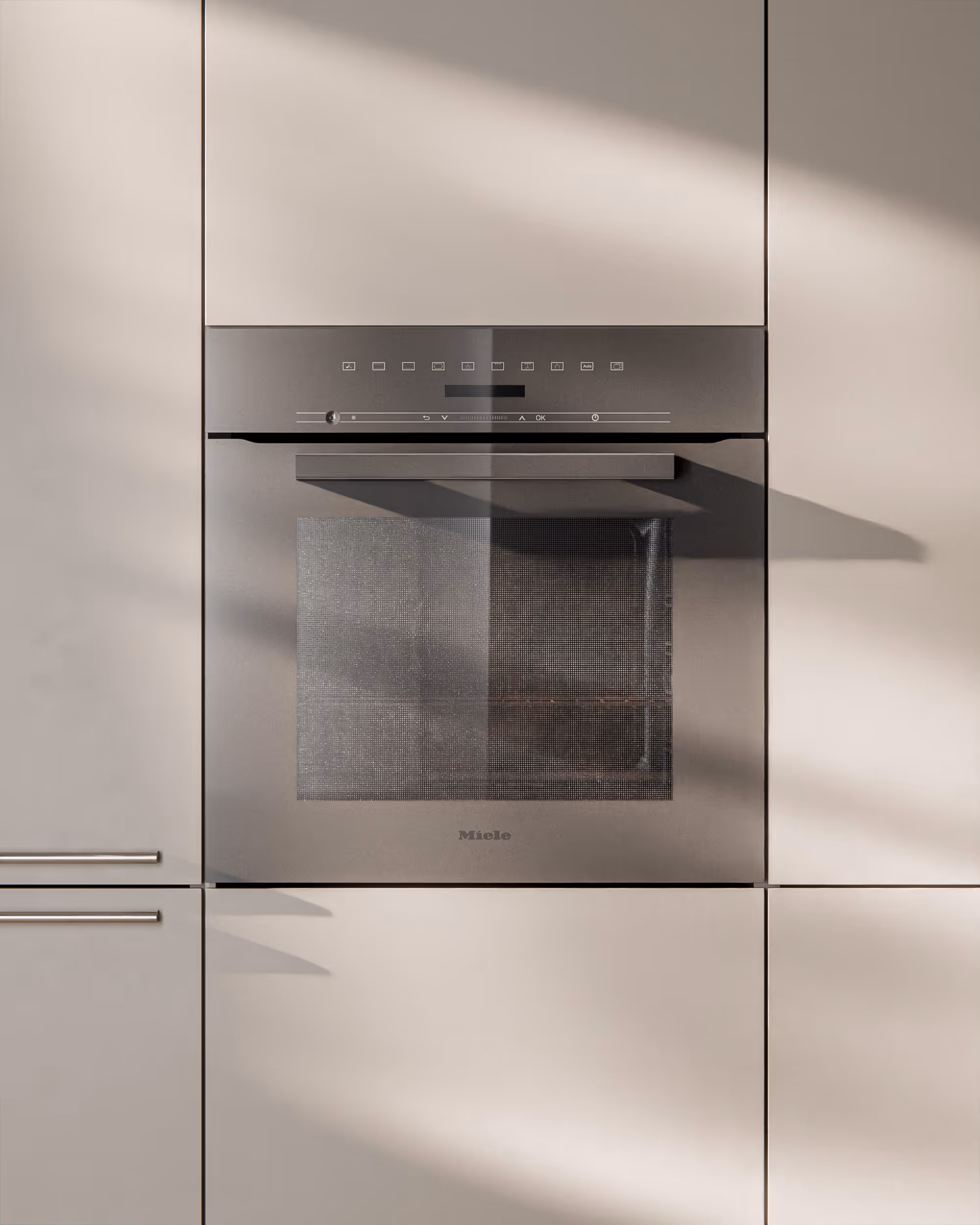 Ein eingebauter grauer Miele-Backofen in einer modernen, hellen Küchenzeile.