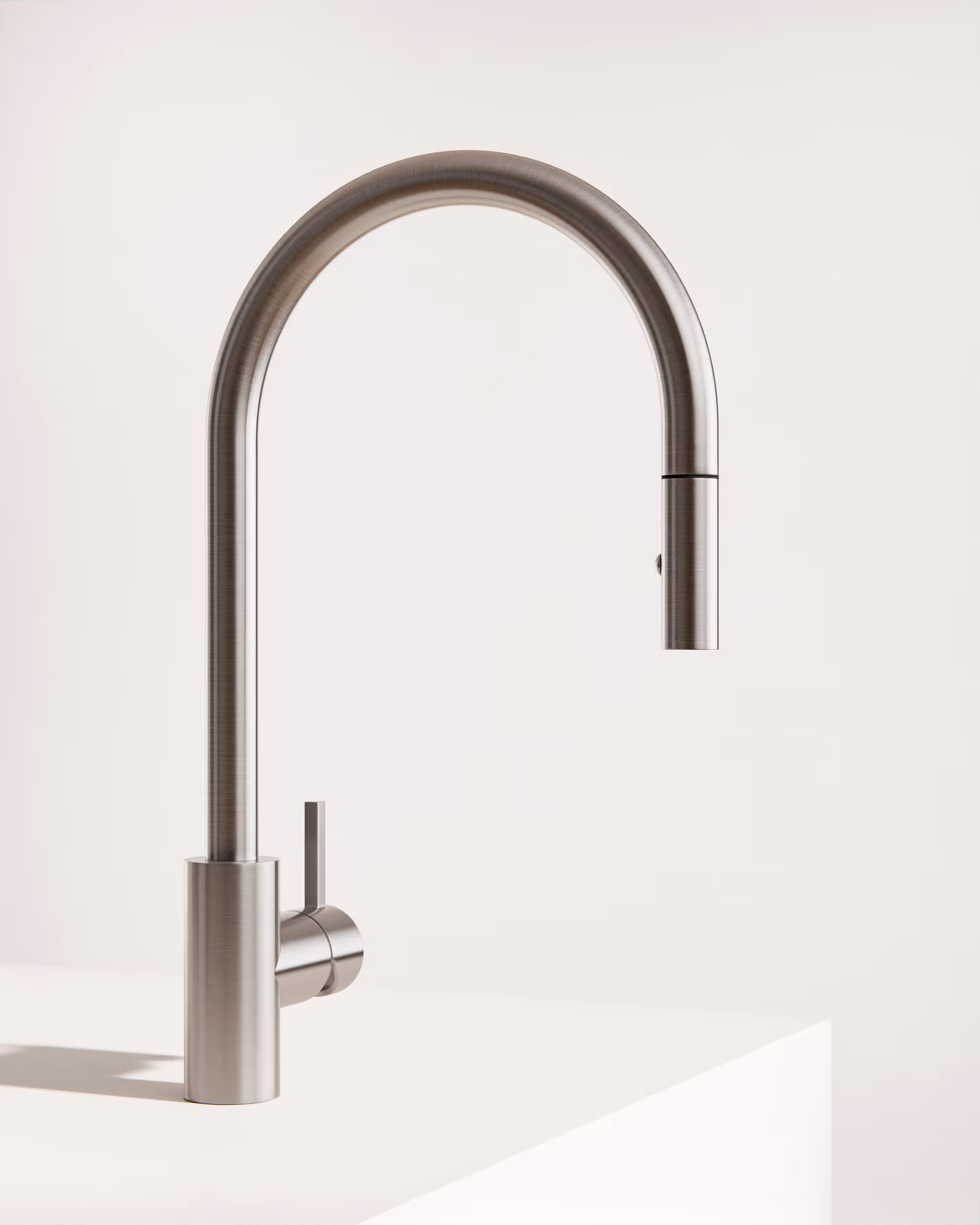 Moderner Edelstahl-Wasserhahn mit hohem Bogen und seitlichem Hebel auf weißer Oberfläche.