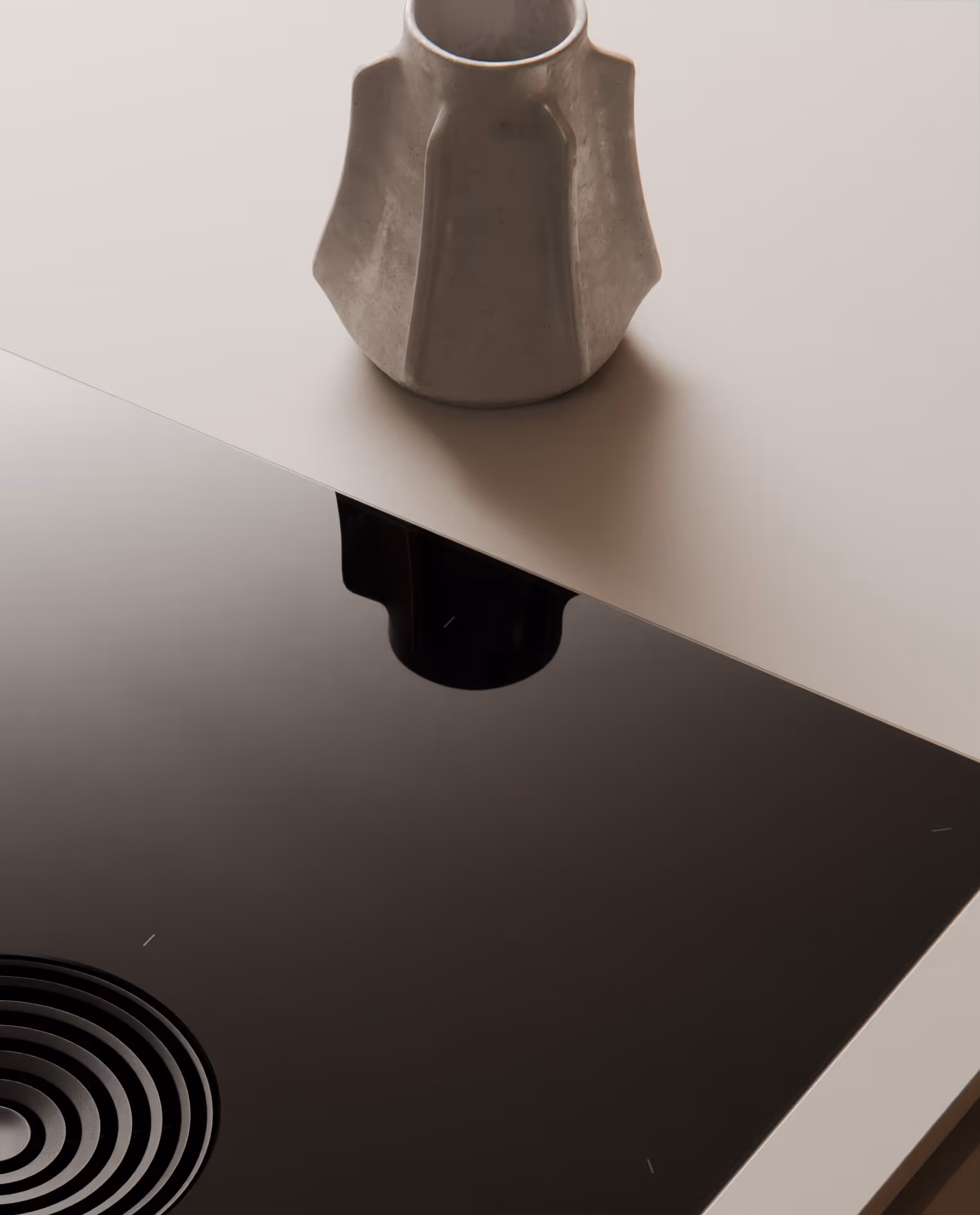 Grauer Keramikkrug auf weißer Oberfläche mit Spiegelung auf schwarzer Glasfläche.