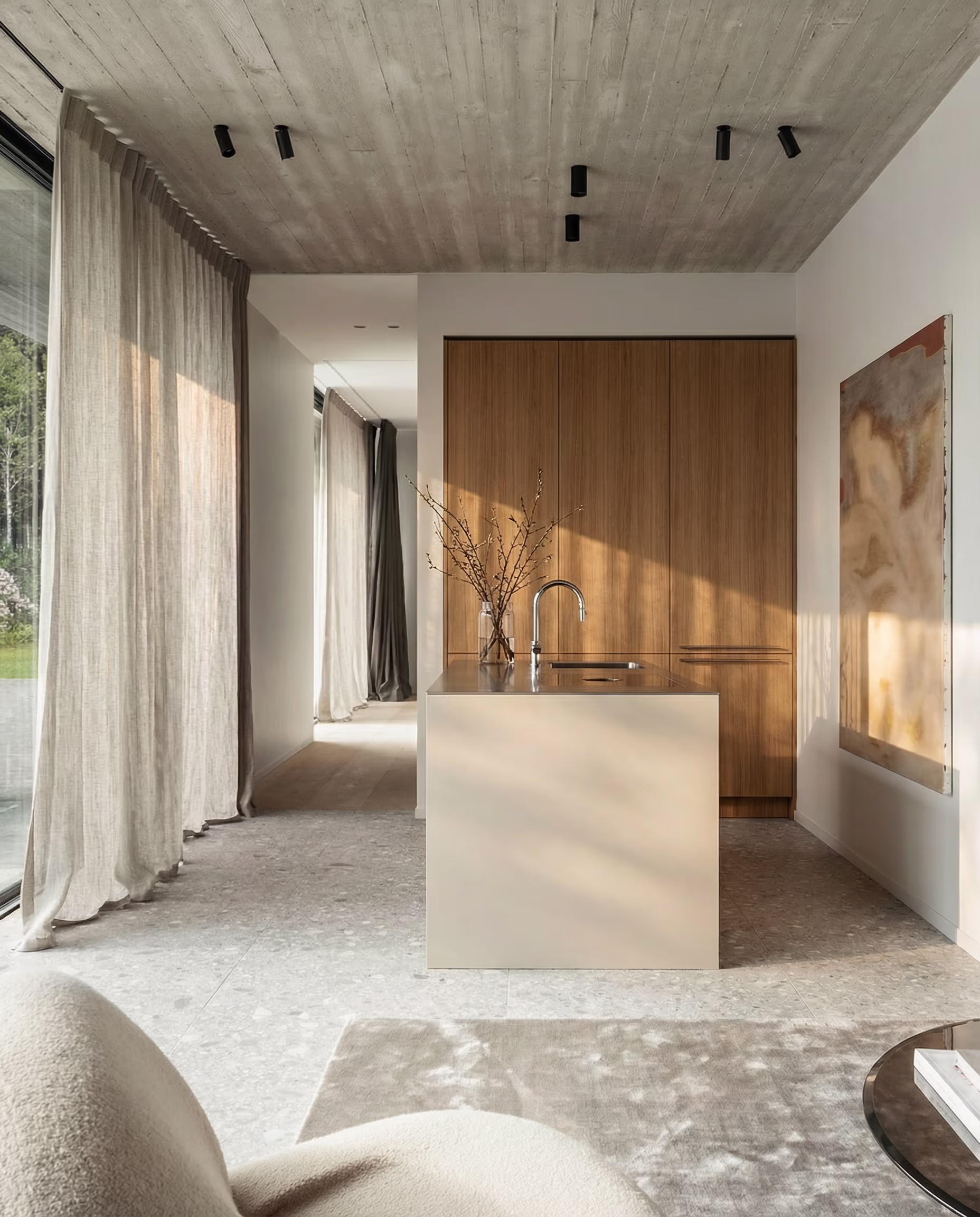 Minimalistische Küche mit Holzschränken, Kücheninsel, großen Vorhängen und Beton-Decke.