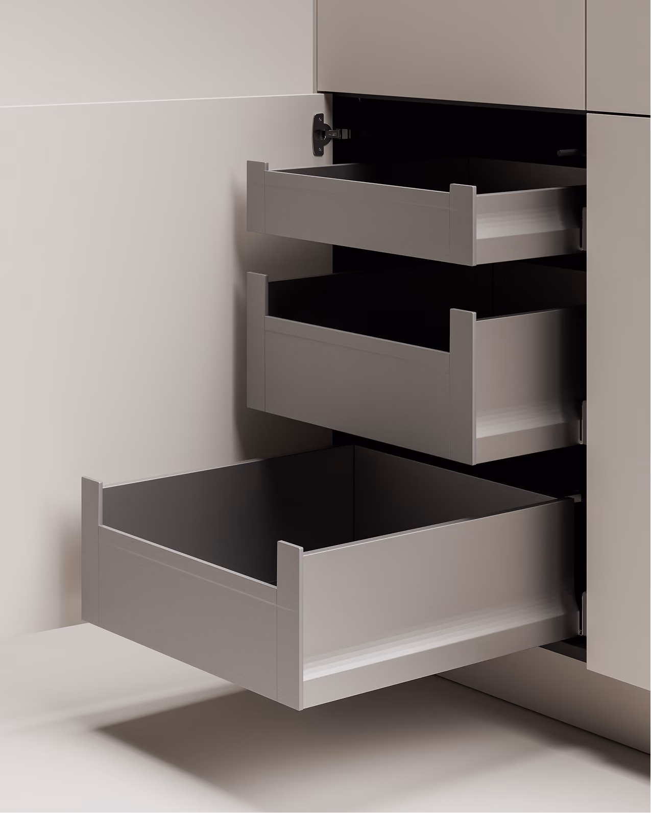 Drei geöffnete graue Schubladen in einem modernen grauen Küchenschrank.