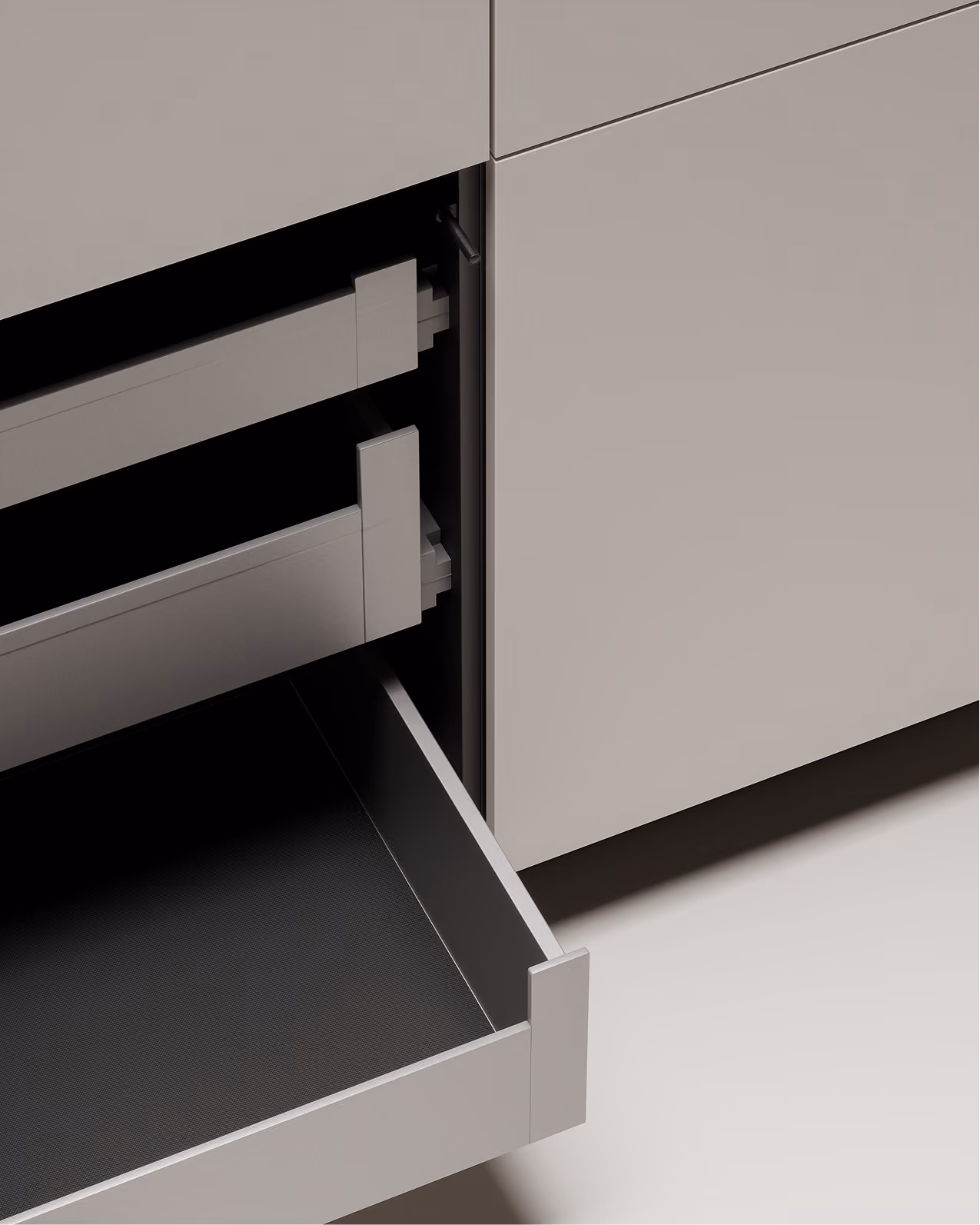 Geöffnete Schublade in einem hellgrauen Küchenschrank mit glatter Oberfläche.