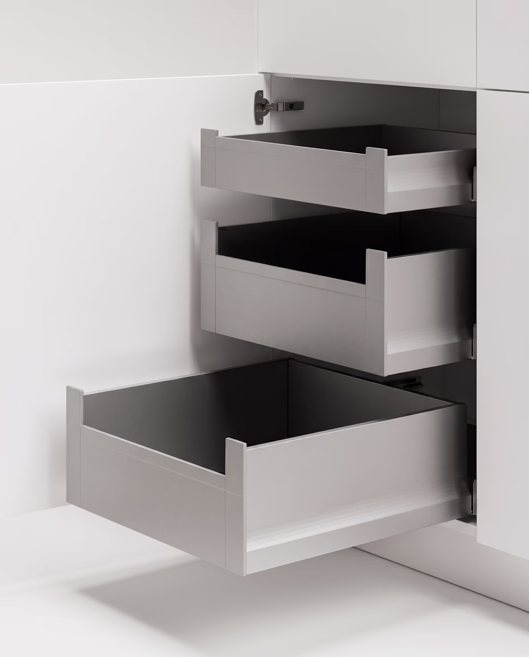 Weiße Küchenschubladen in einem Eckschrank, alle drei Schubladen sind herausgezogen.
