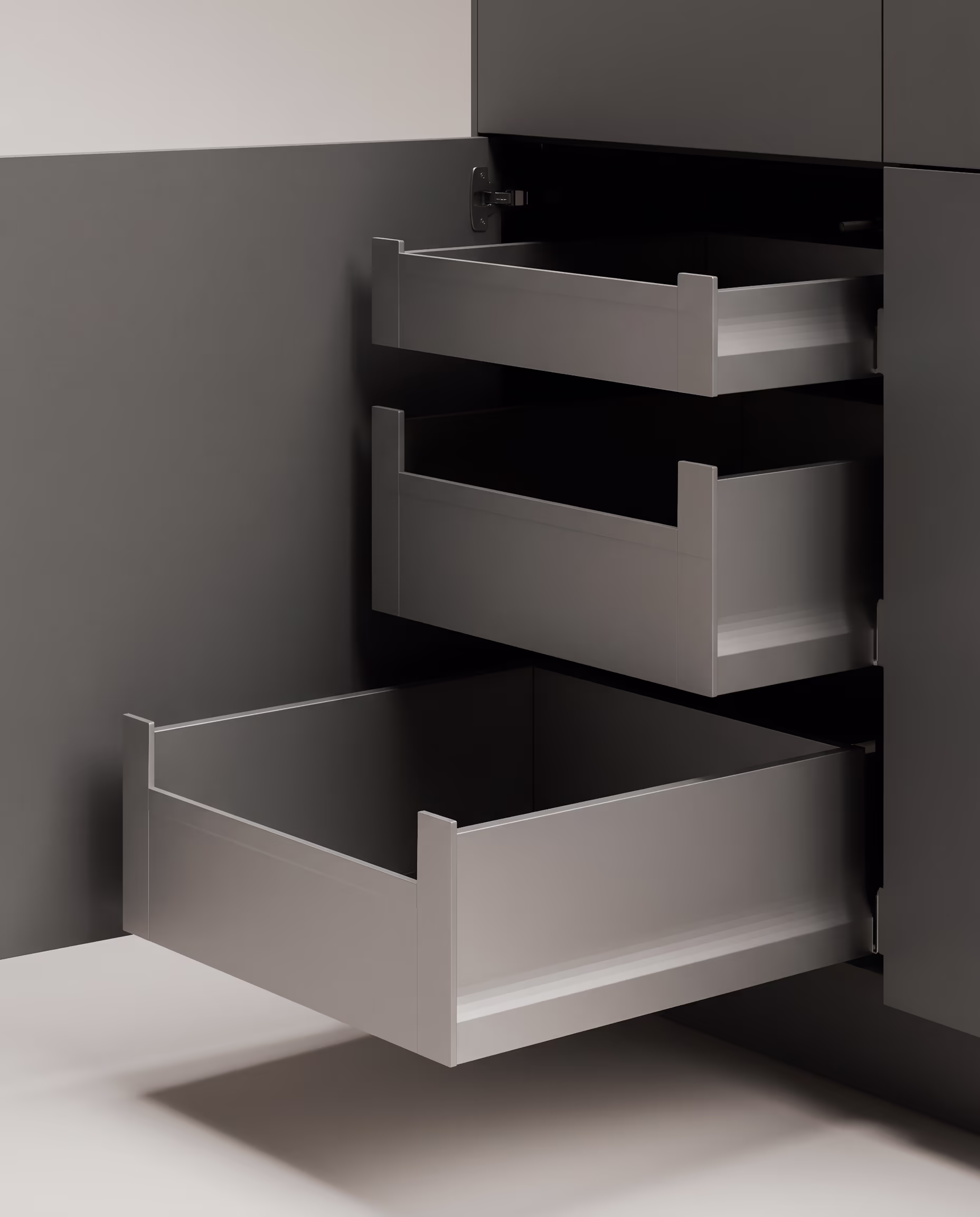 Drei leere graue Schubladen sind in einem grauen Schrank ausgezogen.
