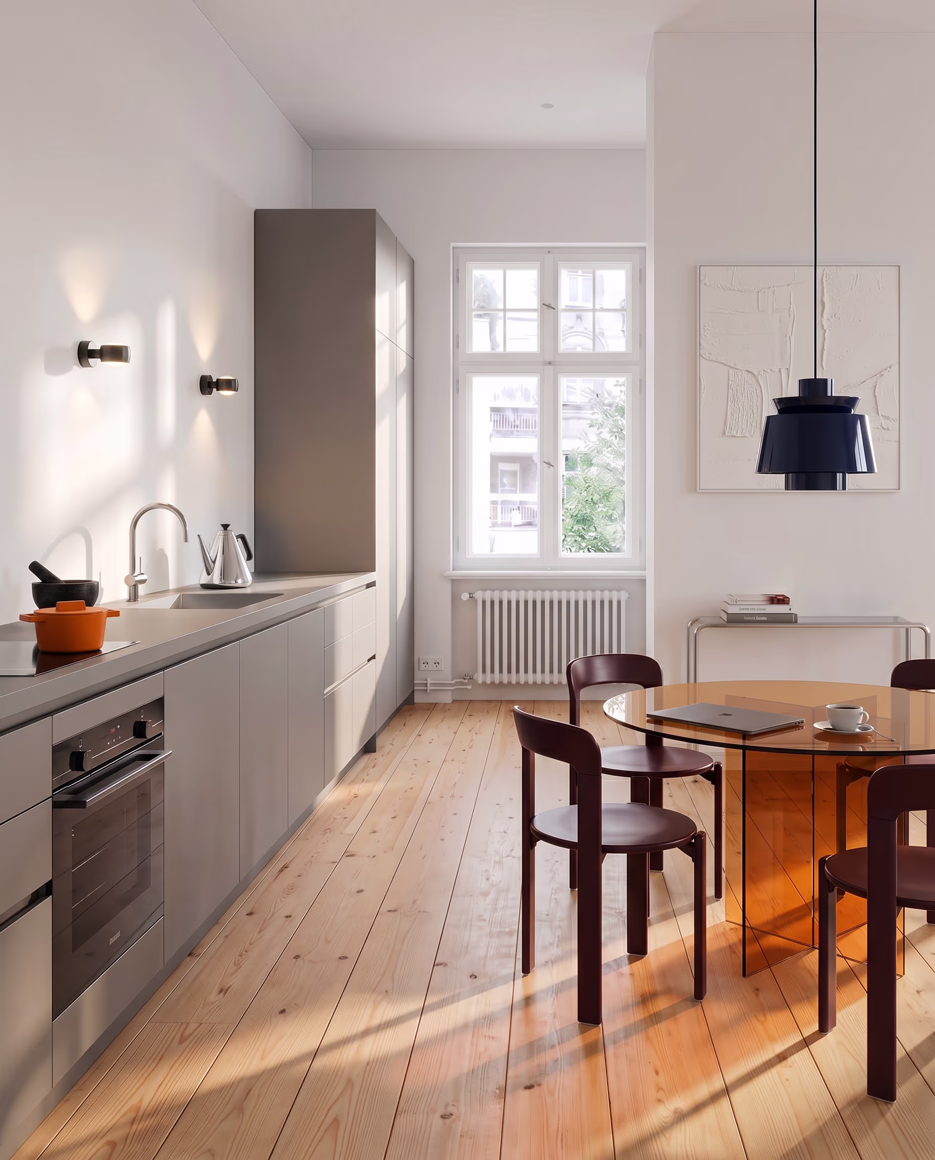 Moderne Küche mit grauen Schränken, einem runden orangenen Tisch und vier dunkelbraunen Stühlen.