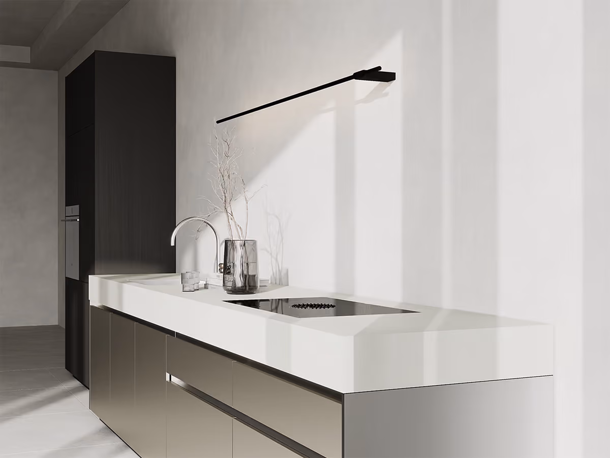 Moderne Küchenzeile mit weißer Arbeitsplatte, Kochfeld, Spüle und schwarzer Wandlampe.