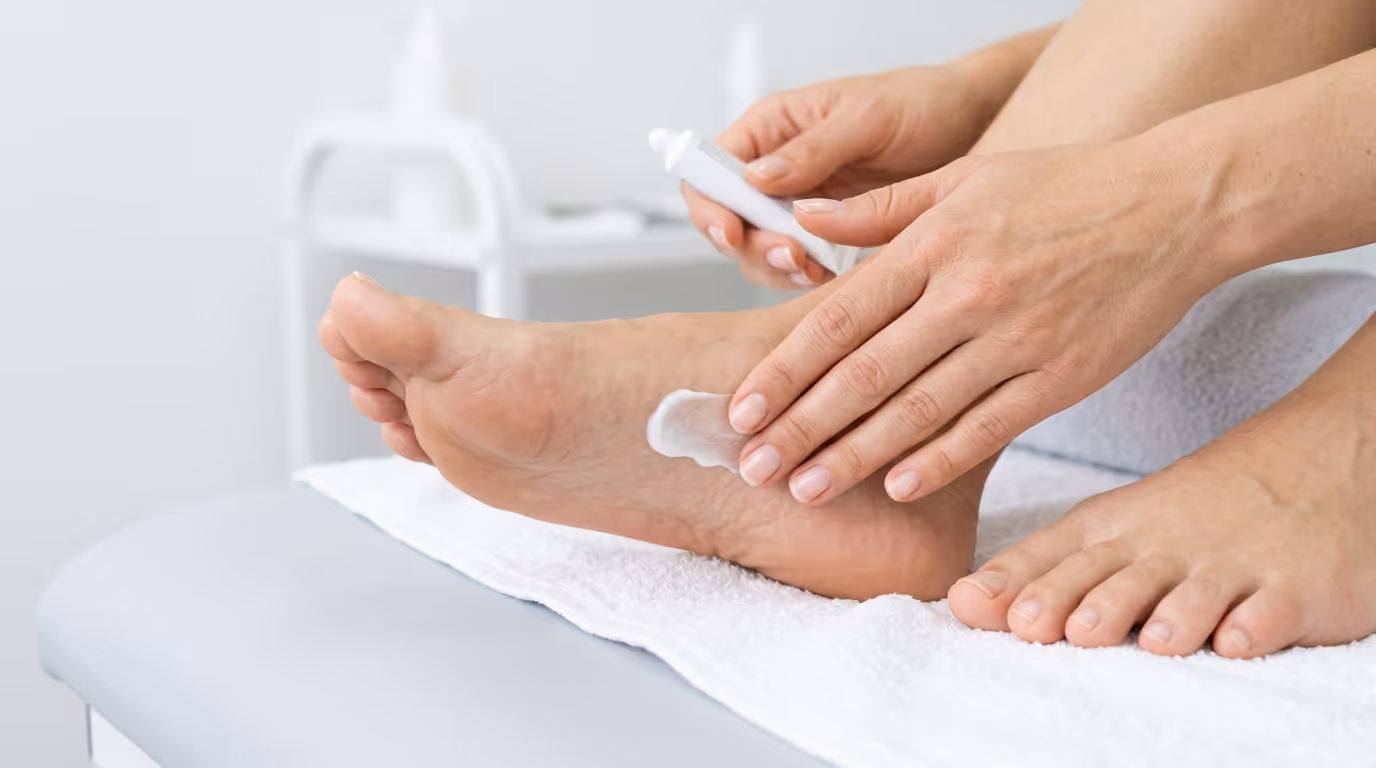 Person applying ointment onto feet.