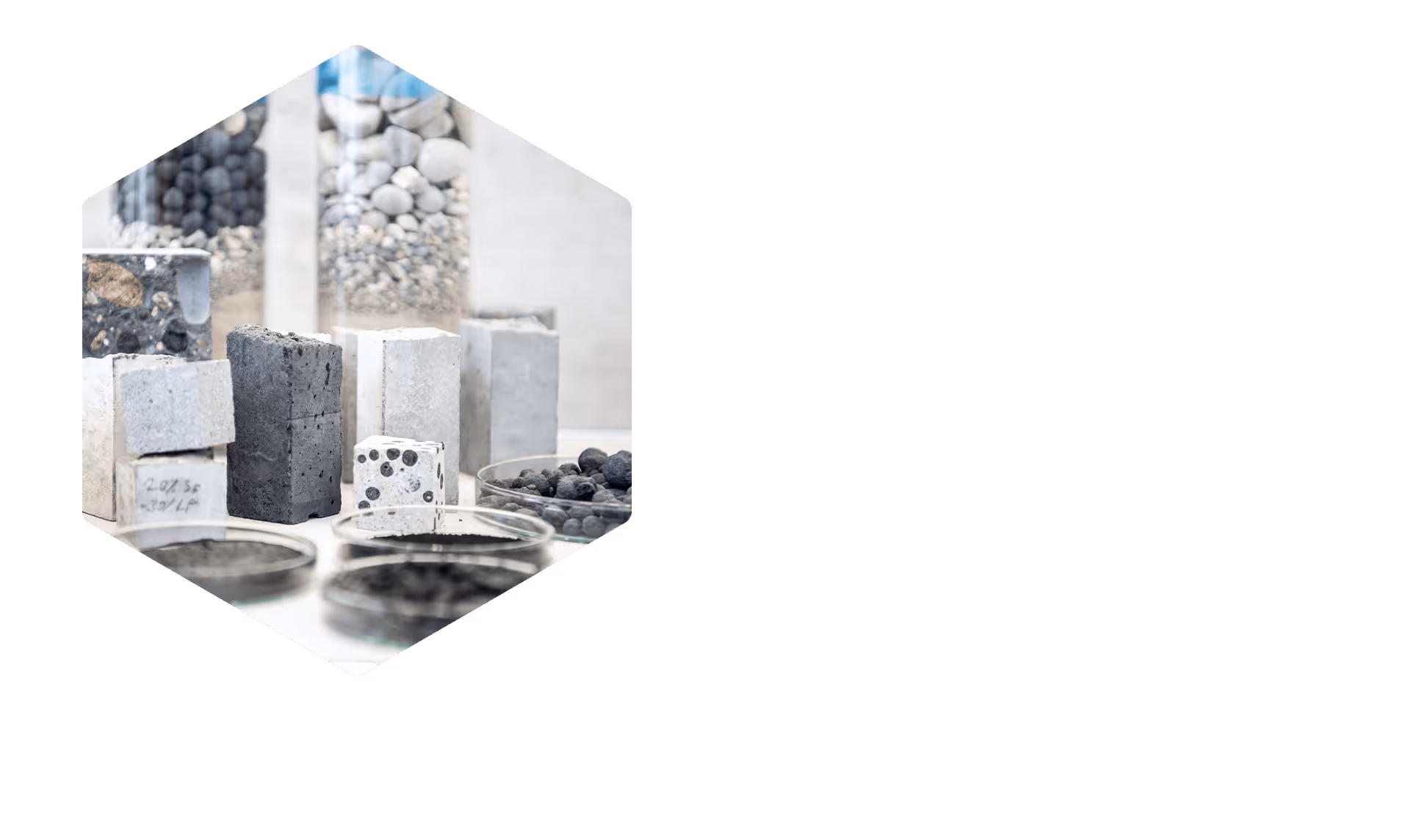 Various concrete and aggregate samples including blocks, pebbles, and powdered materials displayed on a white surface.
