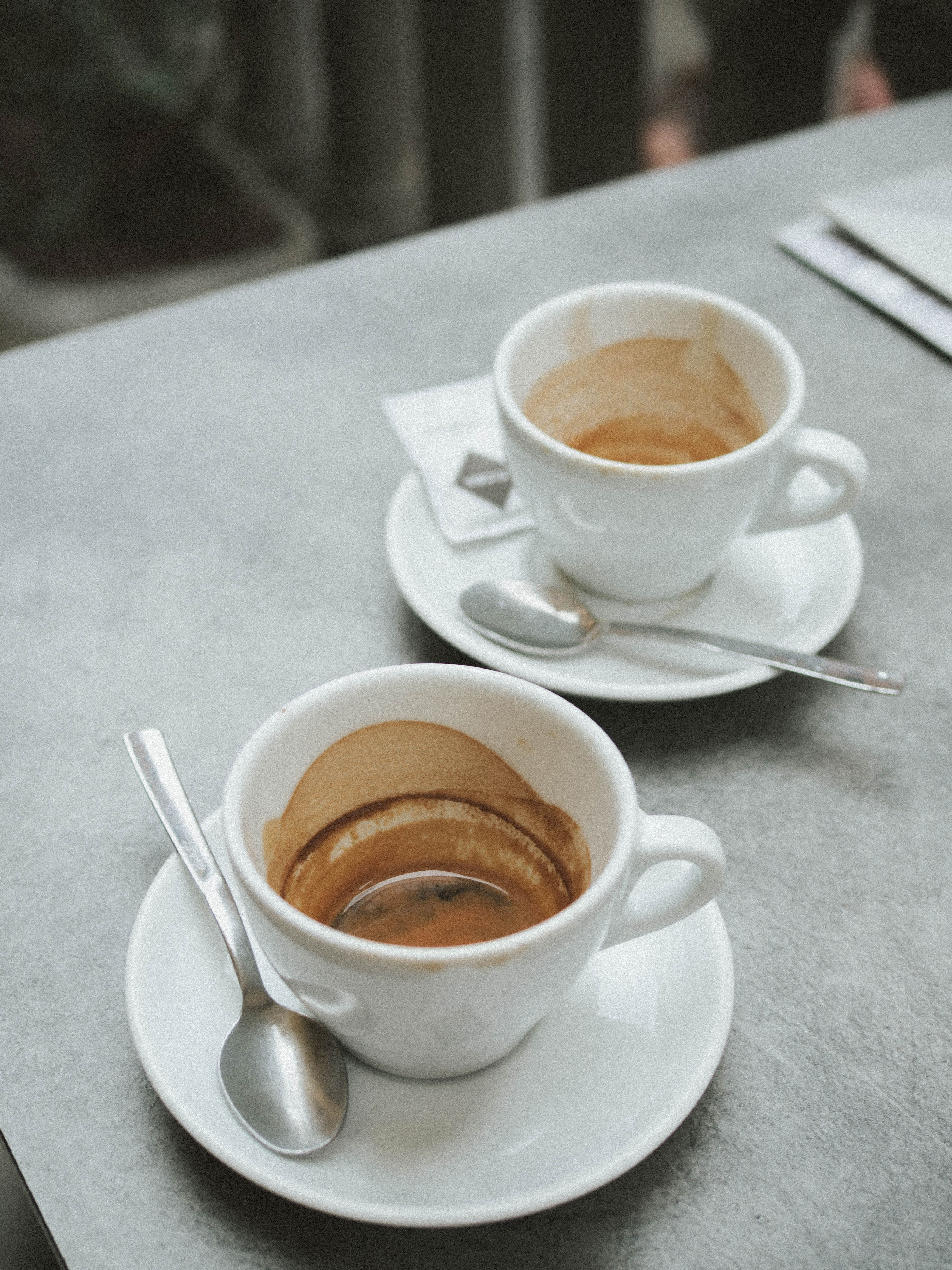 Two espresso cups on a white table, the small ritual between errands on a permesso day in Italy