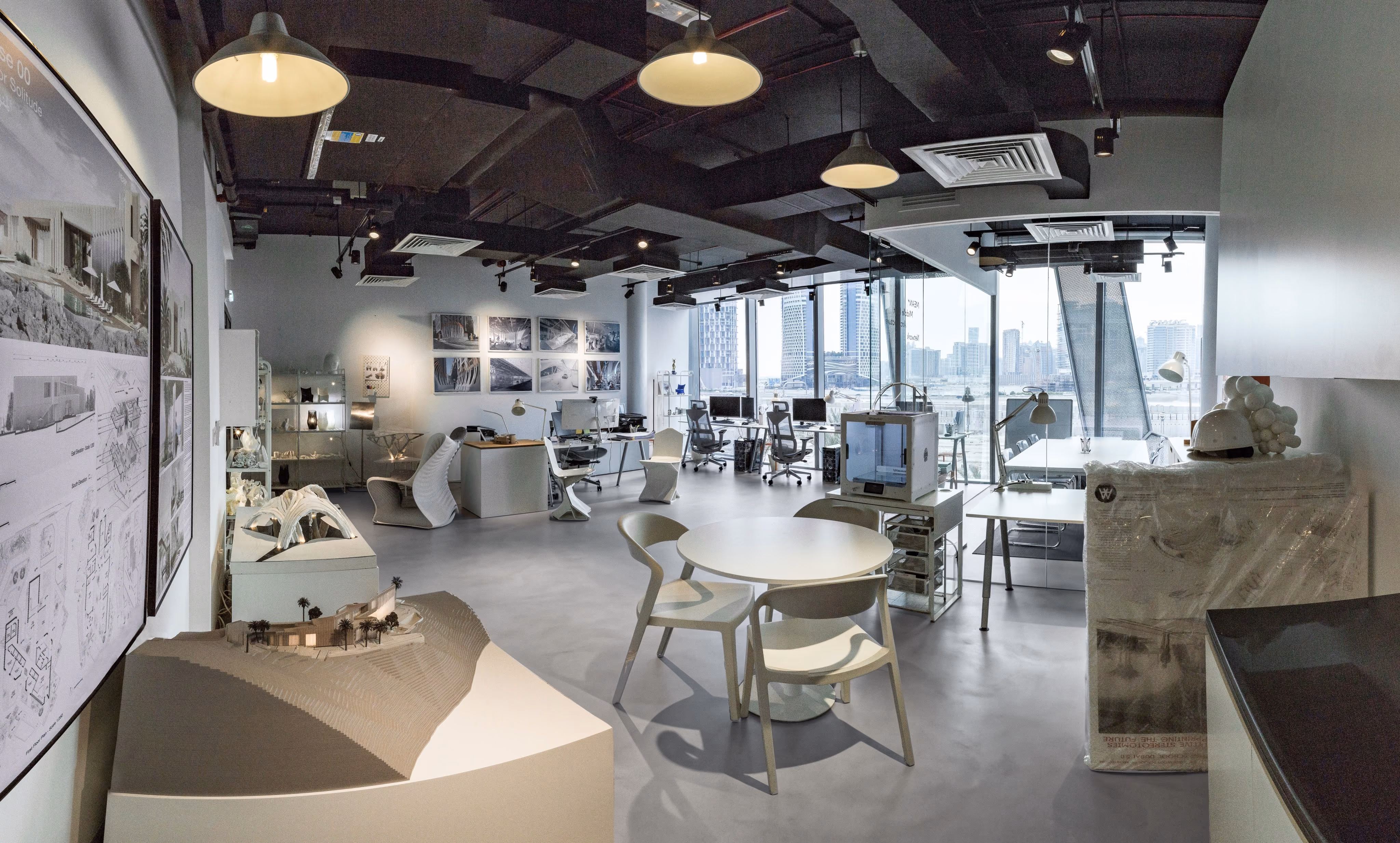 MEAN* studio seen from the model display, pendant lights over the shared table