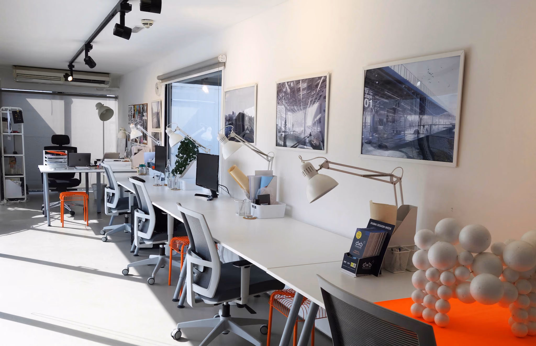 Desks by the window at the MEAN* studio, a 3D-printed model in the foreground