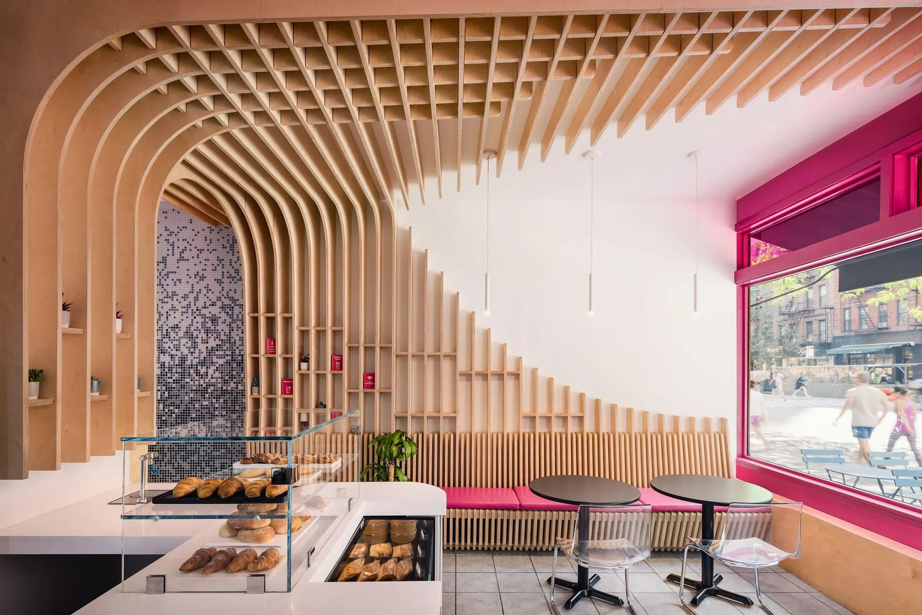 The Migrant Kitchen at 157 Columbus Avenue, New York: birch plywood ribs along the wall and across the ceiling, beside a white counter.