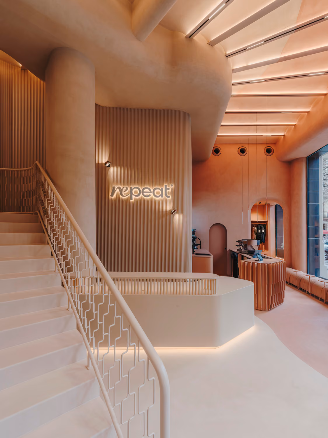 Curved reception and staircase at Repeat Wellness Club in Barcelona.