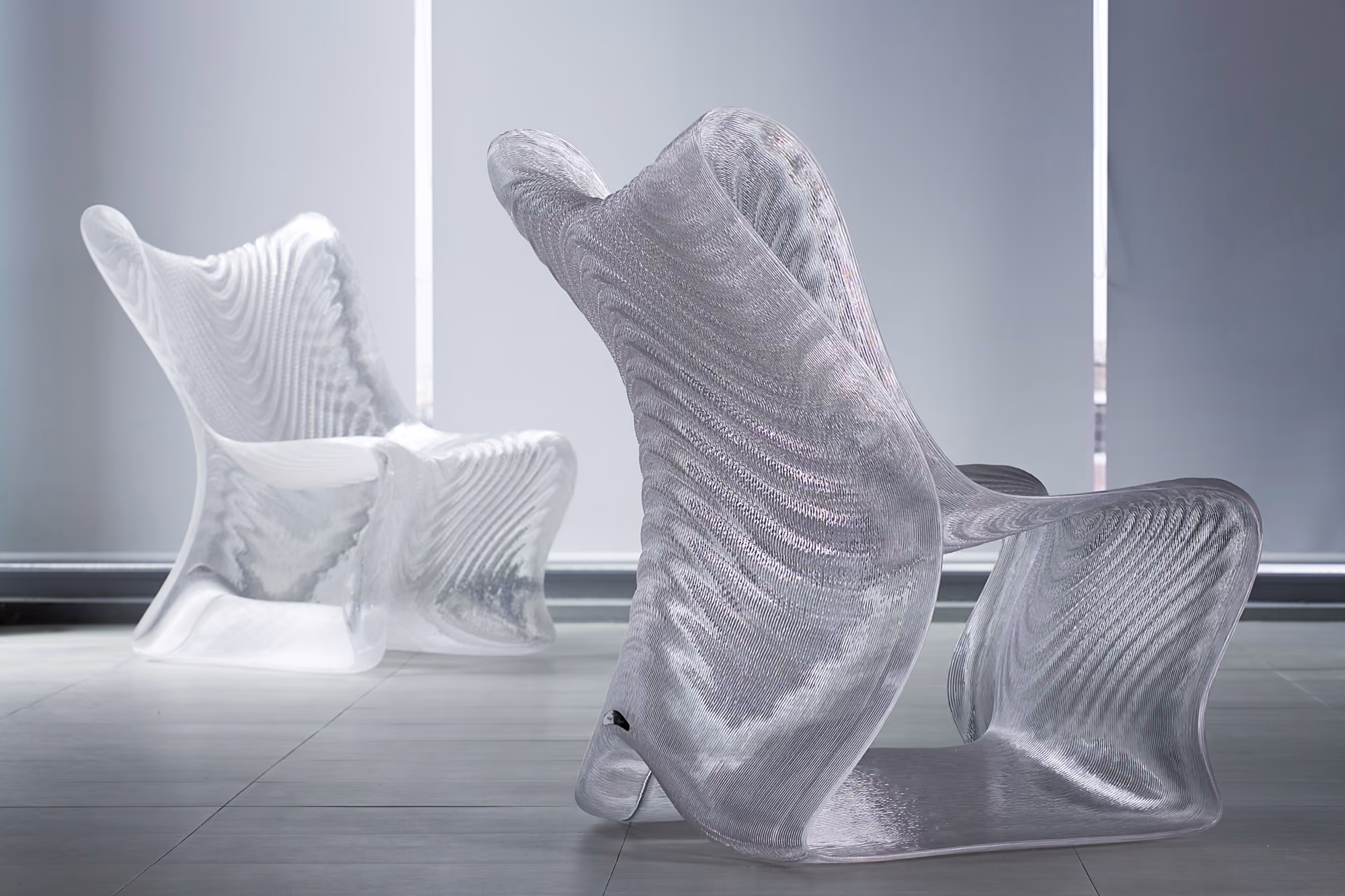 Undulating aquamarine Mawj armchair formed as a continuous robotically printed lattice.