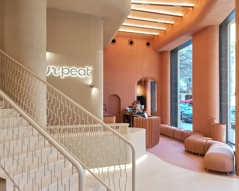 Reception and staircase at Repeat Wellness Club in Barcelona, with the Repeat logo on the wall. Photograph by Edmund Sumner.