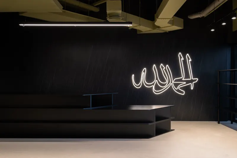 Reception at Send Location in Dubai, with the neon calligraphy wall.