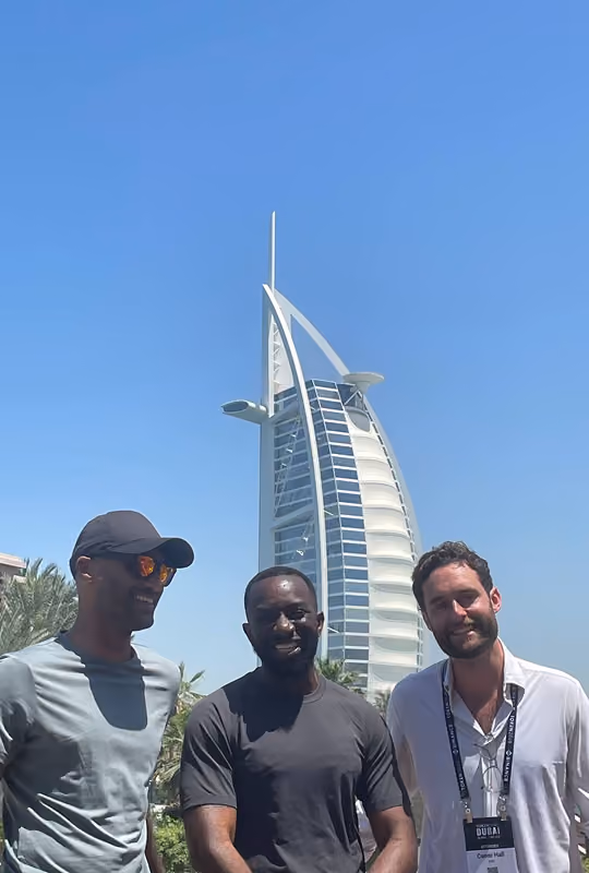 Three Web3 finance professionals attending an OCF Institute event in Dubai near the Burj Al Arab