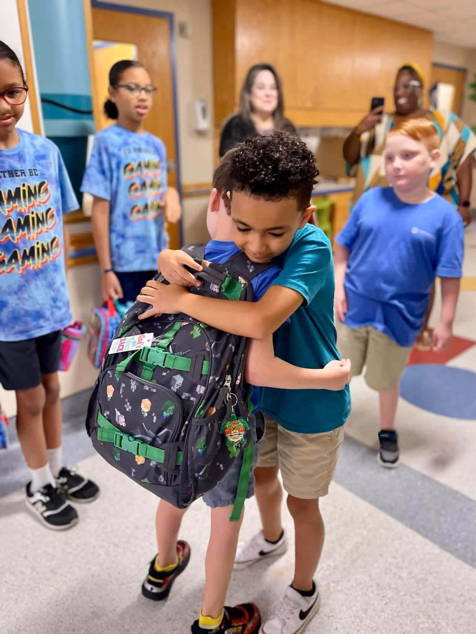 Children at Community School Shreveport hugging in the hallway.