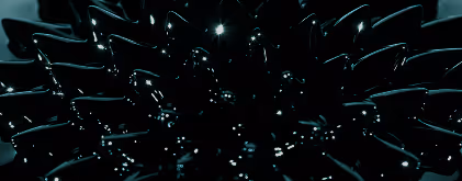 Close-up of a black ceramic flower with glossy petals reflecting light highlights.